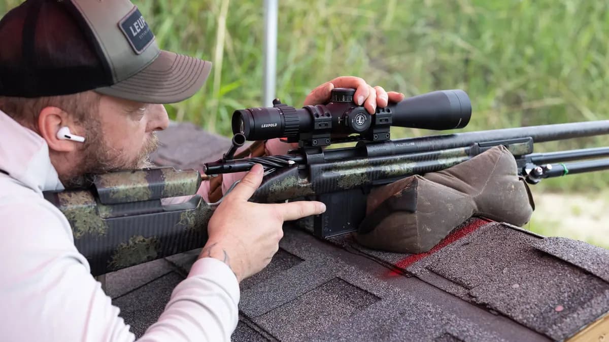 Competitor adjusting a Leupold rifle scope from a supported position